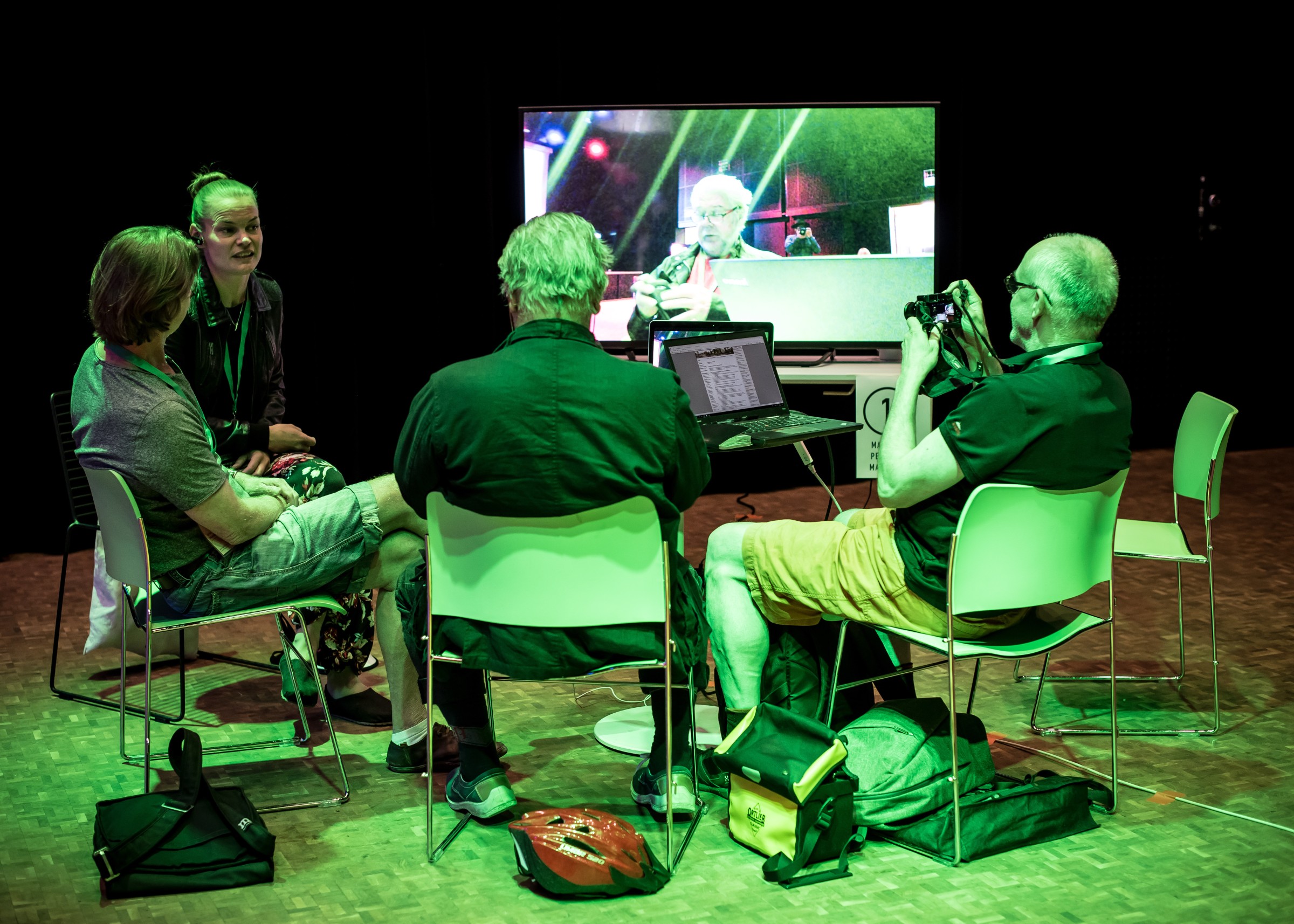 Group of participants talking with avatar actor, looking at the screen