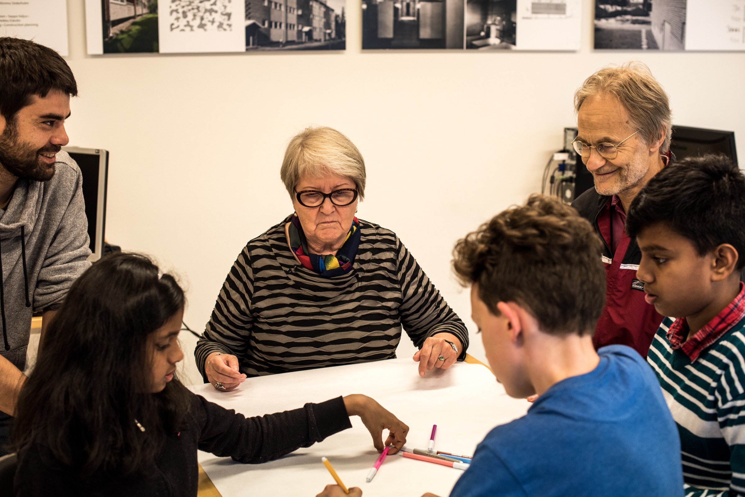 People of different ages sitting at the table in a Maunula-film workshop